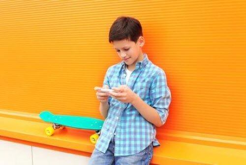 Jongen speelt iets op zijn mobiel