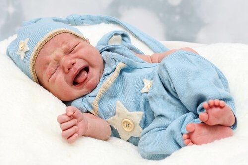 Huilende baby in blauw pakje