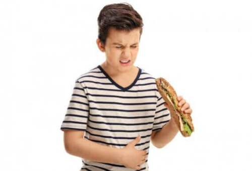 Jongen met indigestie eet broodje