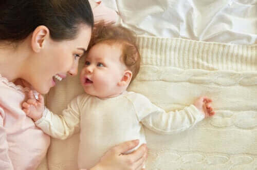 Moeder en baby liggen op bed