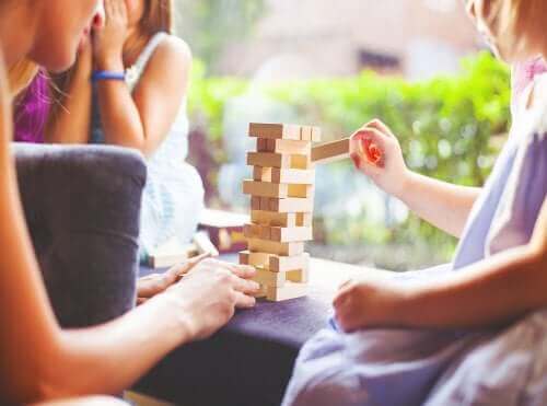 Moeder speelt Jenga met dochters